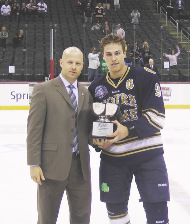 Anders Lee accepts the 2012 Ice Breaker Tournament championship trophy from College Hockey Inc.'s Mike Snee.