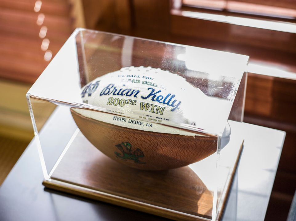 Amongst other footballs featured in his office, Brian Kelly's 200th career win ball is centered in a case.