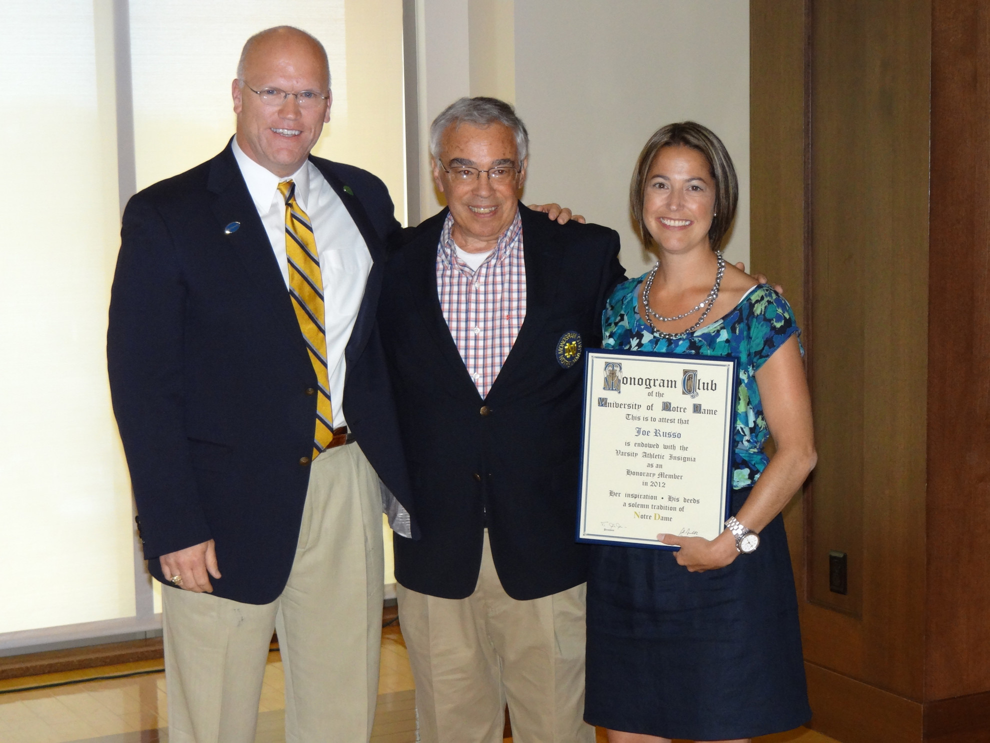 Former Director of Financial Aid Joe Russo Awarded With Honorary Monogram Joe Russo accepts his honorary Monogram scroll and blazer from executive director Beth Hunter