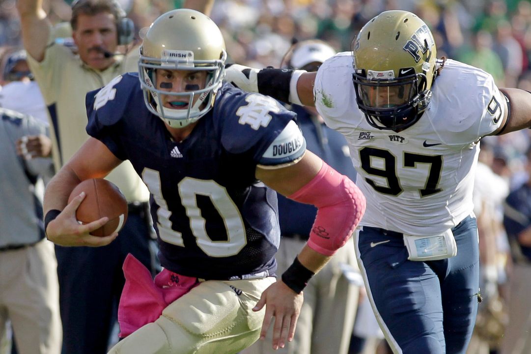 Notre Dame quarterback Dayne Crist eludes Pittsburgh defensive tackle Jabaal Sheard on his way to a 10-yard touchdown.