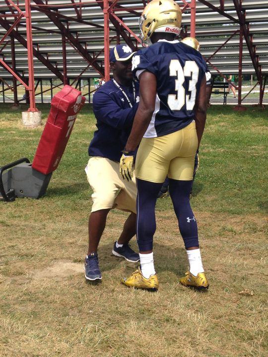 Autry Denson shows freshman running back Josh Adams some proper blocking technique 20 years after he learned similar things at Culver.