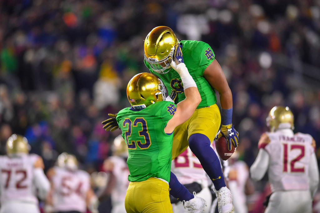 Drue Tranquill (23) and Daelin Hayes (9) celebrate a fumble recovery in the first half.