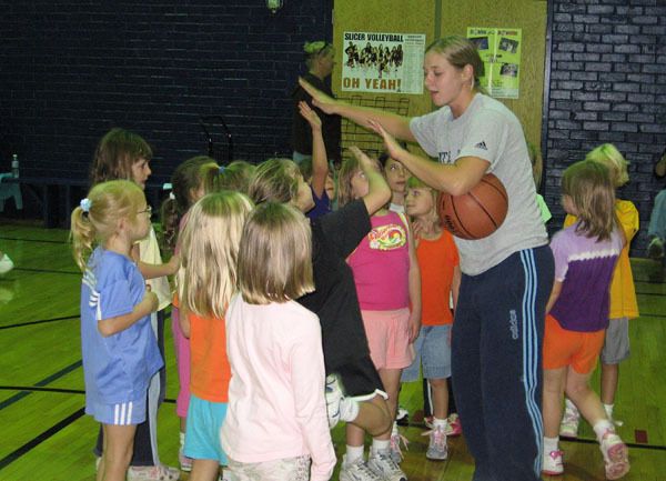 Freshman guard Melissa Lechlitner high-fives several campers at the clinic.