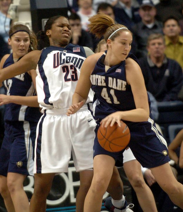 Courtney LaVere backs the ball in as Connecticut's Willnett Crockett tries to guard her in the first half.