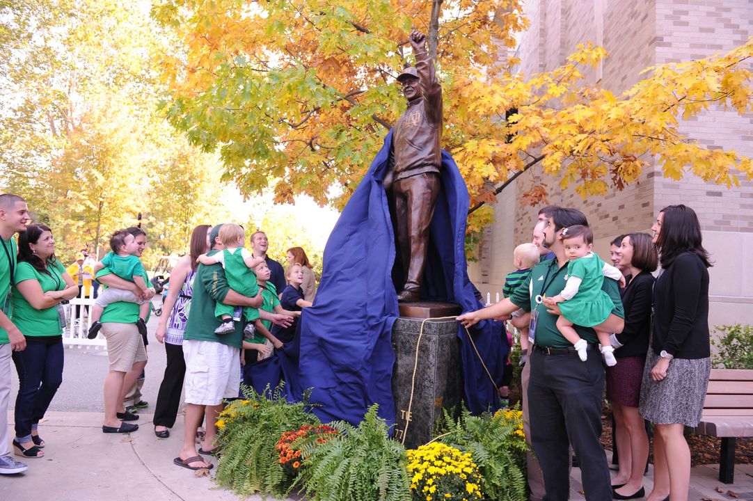 Members of the Devine family help unveil the new sculpture outside Gate A of Notre Dame Stadium (photo by Mike Bennett).