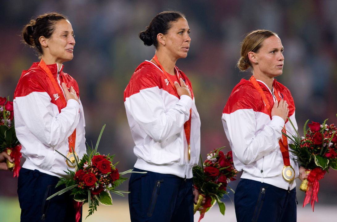 Kate Markgraf, left, is shown with former Irish and USWNT teammate Shannon Boxx and Christie Rampone during the medal ceremony at the 2008 Beijing Olympics, where the U.S. won gold. Markgraf will join the ESPN coverage team as a color commentator for UEFA EURO 2016 to become the first woman to call a major men's soccer tournament on American television.
