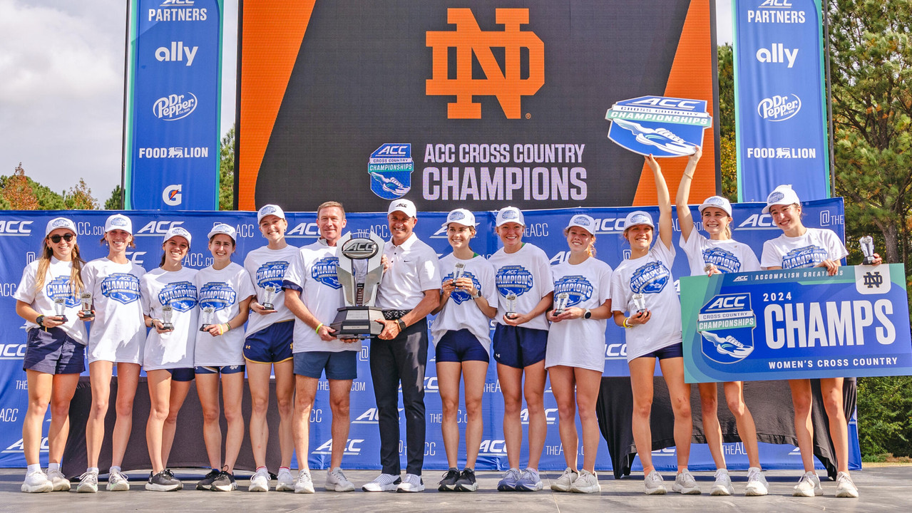 The women's cross country team poses with their championship trophy.