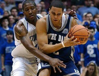 Irish Win Big East Opener Over Seton Hall, 66-65 Jordan Cornette protects the ball as he is pressured by Seton Hall's J.R. Morrris during the first half.