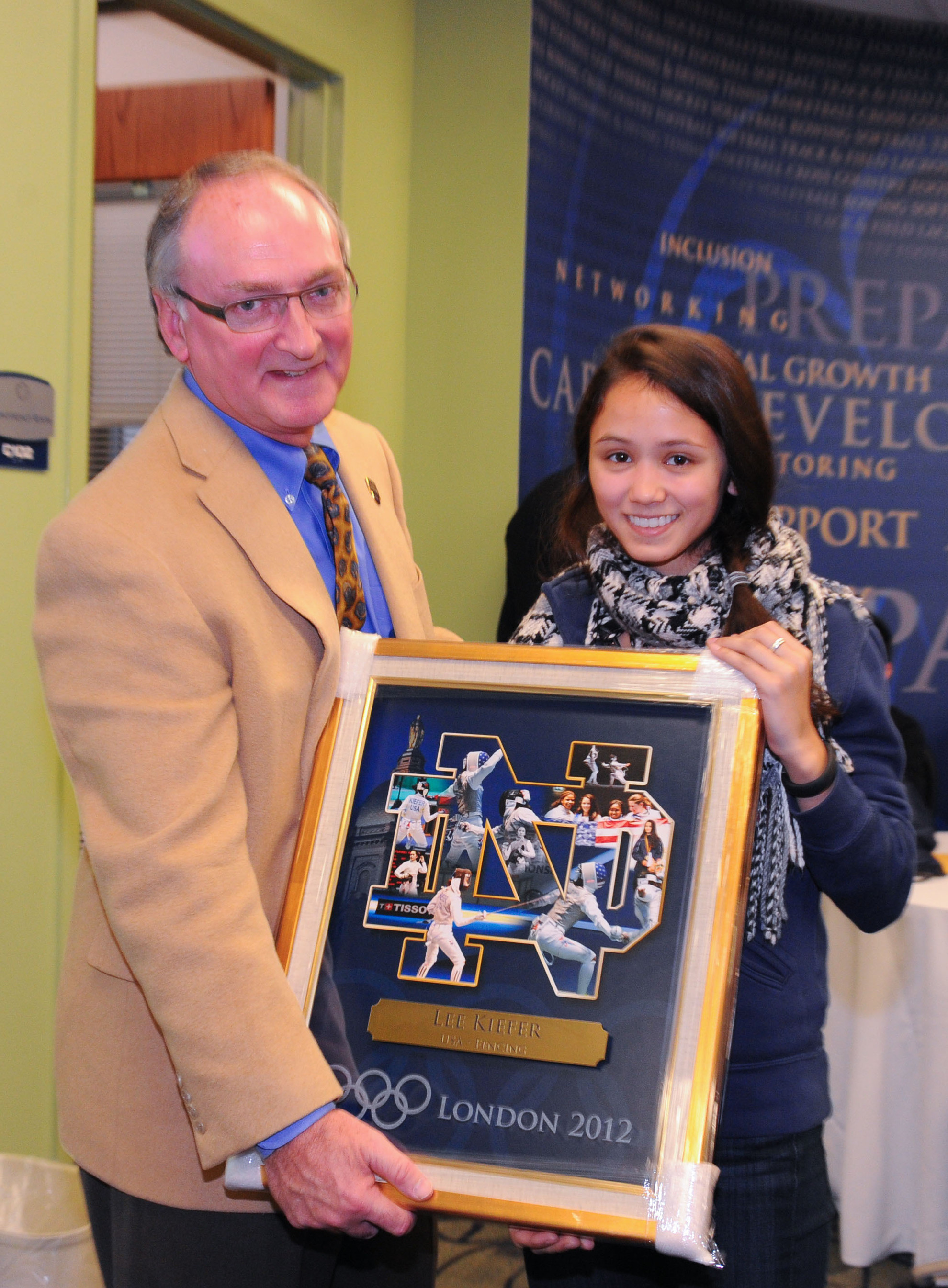 Monogram Club Musings: Pittsburgh Edition Jack Swarbrick presents Olympic fencer Lee Kiefer with a commemorative collage to celebrate her competitive achievements (photo courtesy of Mike & Susan Bennett).