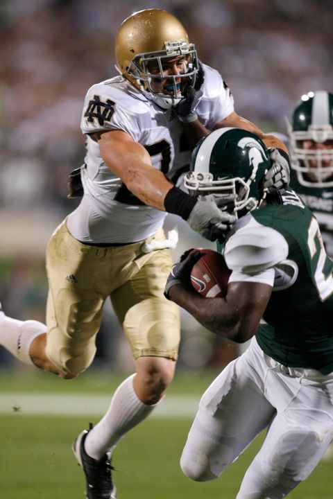Michigan State running back Le'Veon Bell, right, is brought down by Notre Dame's Harrison Smith.