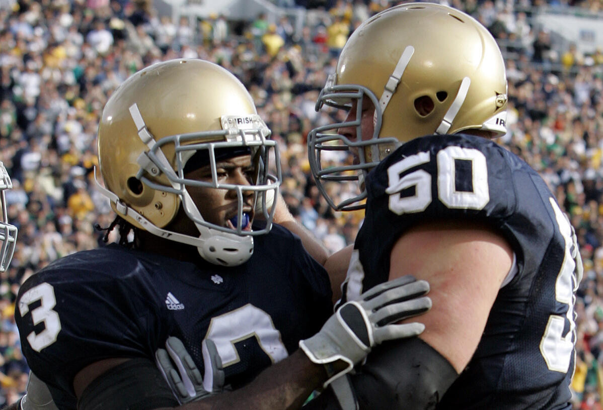 No. 7 Fighting Irish Sink Midshipmen Notre Dame running back Darius Walker, left, celebrates with Dan Santucci after scoring a touchdown on a 13-yard run against Navy in the second quarter. (AP Photo/Michael Conroy)