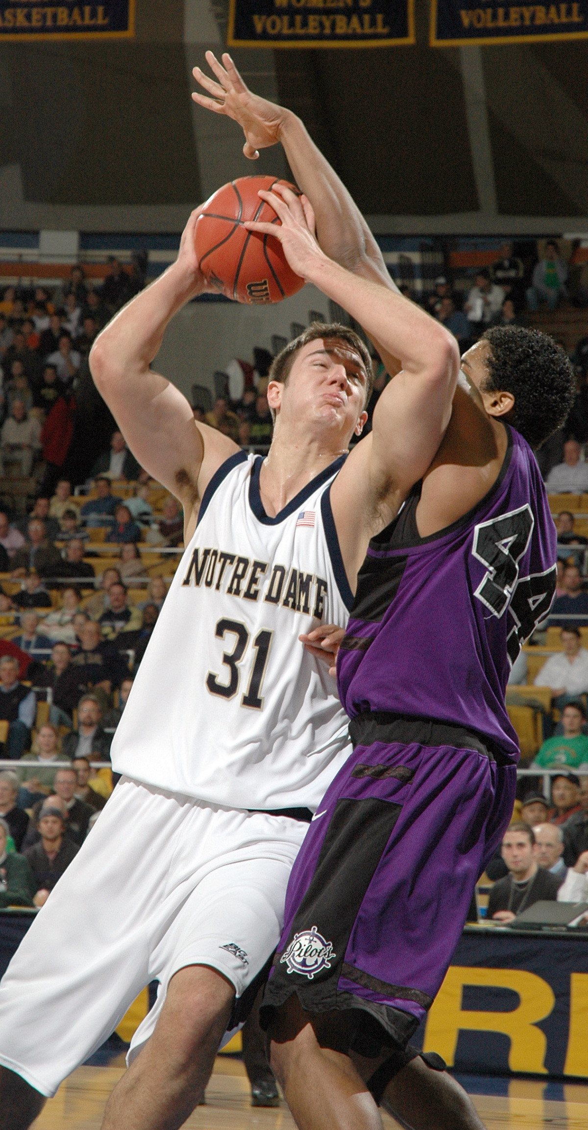 Carter Leads Irish Past Pilots Rob Kurz drives the lane as Portland forward Jamie Jones defends.