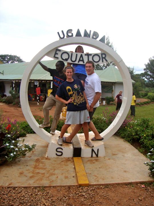 JoHanna Manningham (front left) and Jordan Stumph (front right) pose with friends at an Equator marker in Uganda.