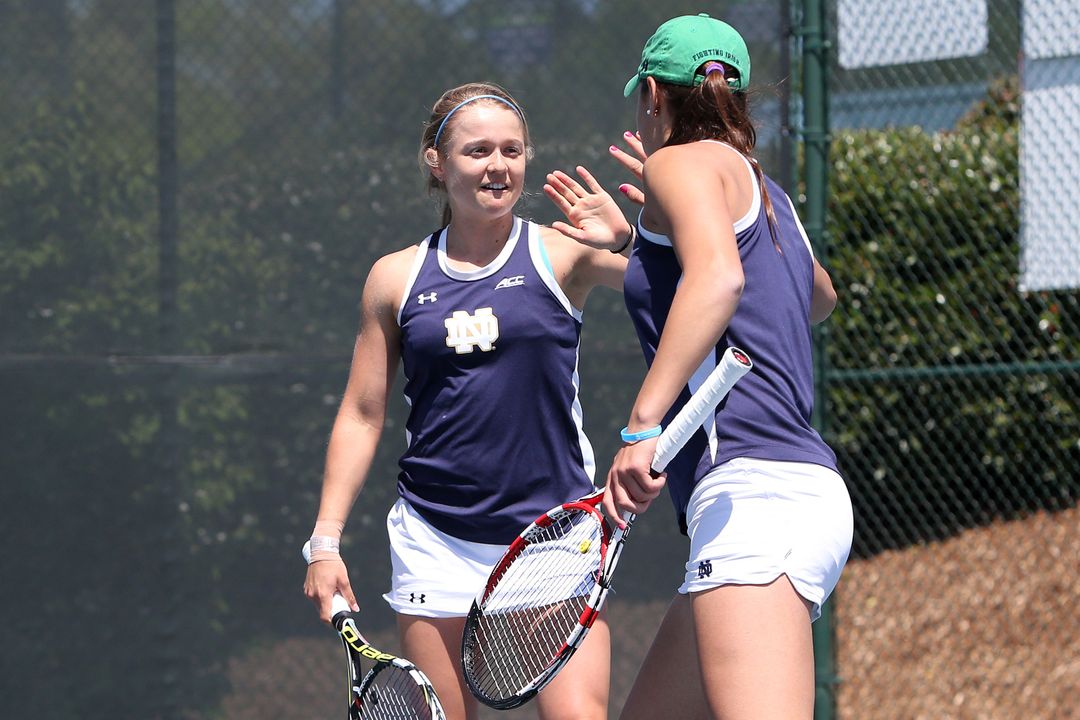 Sophomore Monica Robinson (facing) high-fives partner Quinn Gleason (back turned) during the pair's match against Florida State in the ACC Tournament.