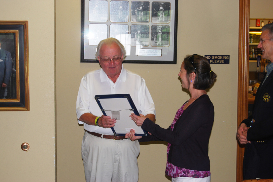 Monogram Club executive director Beth Hunter presents Phil Singleton with his honorary monogram.
