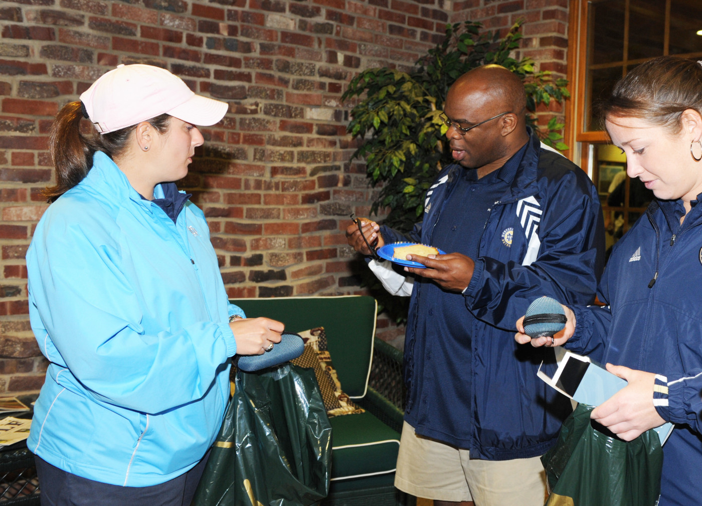 2nd Annual Riehle Open Reggie Brooks (center) with Kyle Veltri (left) and Erika Whitman (right) checkout the sunglasses donated by Monogram Club Board Member Jennifer Slosar-Smith.