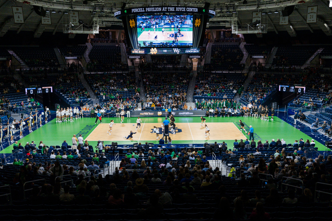 Wide-angle photo of a volleyball match with fans inside Purcell Pavilion