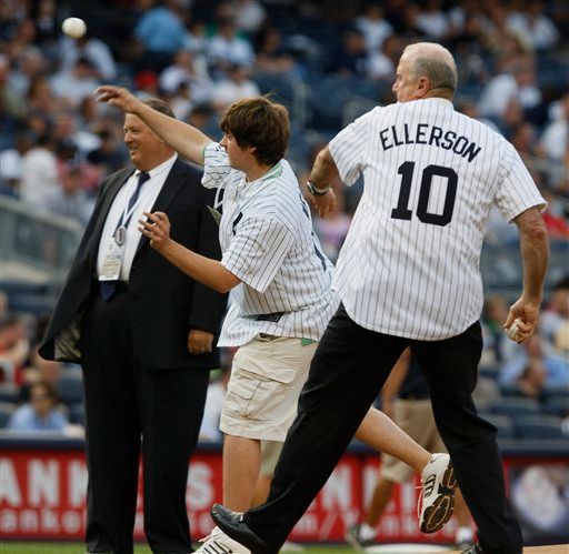 Charlie Weis watches his son Charlie Jr. throw out a ceremonial pitch before the New York-Baltimore game at Yankee Stadium on Monday. (AP Photo/Kathy Willens)