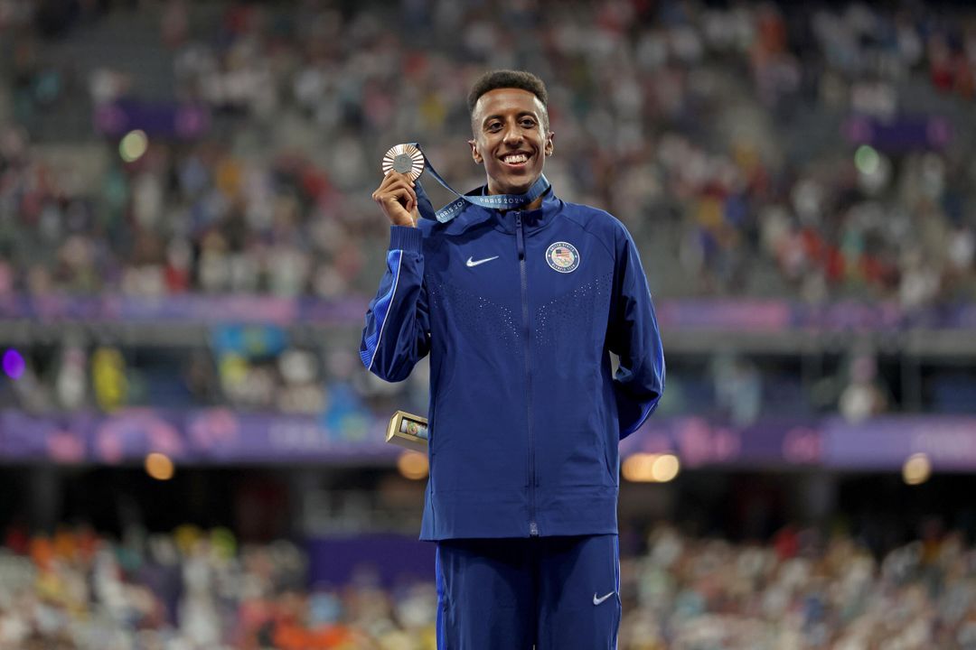 Image of Yared Nuguse holding his bronze medal and smiling.