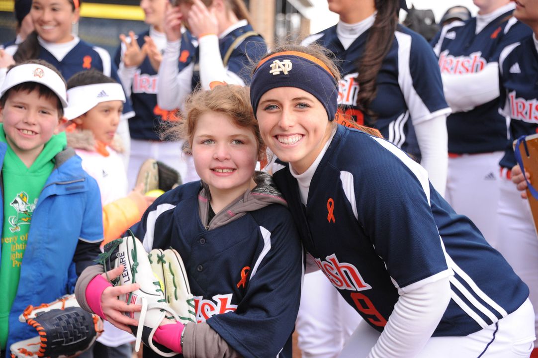 Tatum Gumpf, daugher of Notre Dame head coach Deanna Gumpf and a leukemia survivor, with Irish third baseman Katey Haus during Strikeout Cancer 2013