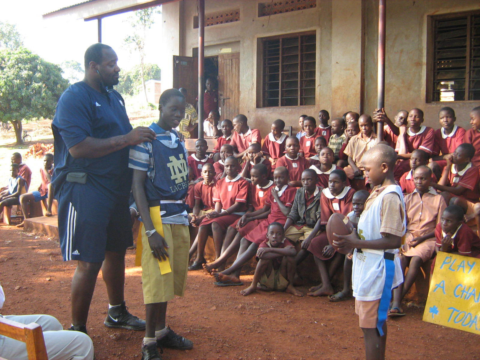 Monogram Winners Teach Ugandan Children To “Play Like A Champion Today” McBride instructs children at St. Jude's Primary School in Jinja about the rules of American football.