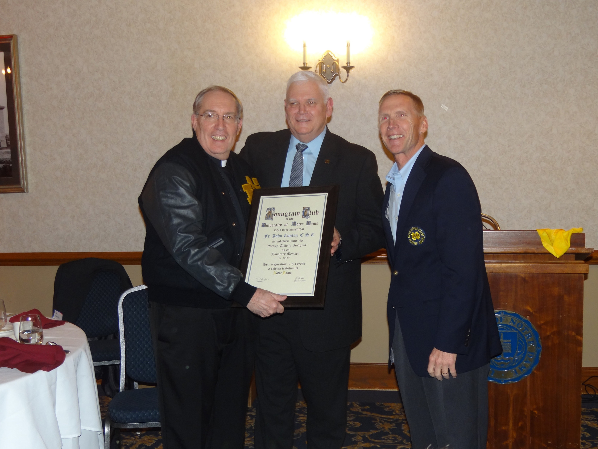 Rev. John E. Conley, C.S.C. ’73, ’77 Awarded Honorary Monogram Rev. John E. Conley, C.S.C. '73, '77 with Notre Dame hockey head coach Jeff Jackson (honorary) and Monogram Club Second Vice President Don Casey ('82, '83, swimming & diving).