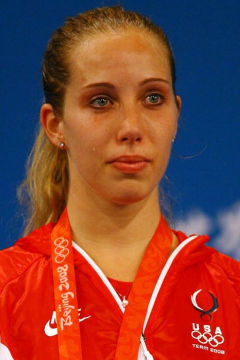 Former Notre Dame All-American and 2006 NCAA sabre champion Mariel Zagunis cries as she watches the American flag rise and the Star Spangled Banner play during the medal ceremony for the women's sabre competition at the 2008 Olympics in Beijing, China.