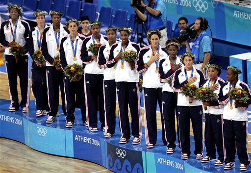 Former Notre Dame All-America center Ruth Riley (second from left) and her U.S. teammates listen to the National Anthem after winning the Olympic gold medal with a 74-63 victory over Australia on Saturday in Athens, Greece. <i>(photo provided by the Associated Press)</i>